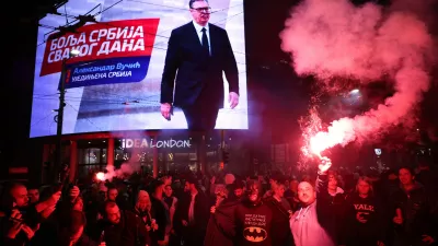 People celebrate after Aleksandar Vucic, leader of the right-wing Serbian Progressive Party (SNS), seen on the top display, conceded defeat in the parliamentary election in Belgrade, Serbia, Sunday, Oct. 25, 2026. (AP Photo/Armin Durgut)