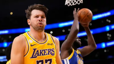 Los Angeles Lakers forward/guard Luka Doncic, left, looks to fans after scoring as Golden State Warriors forward/center Draymond Green takes the ball during the first half of an NBA basketball game Wednesday, Oct. 21, 2026, in Los Angeles. (AP Photo/Mark J. Terrill)