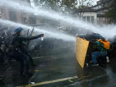 FILE PHOTO: Protesters take cover behind a plywood board as French riot police and gendarmes use a water canon amid clashes during an authorised demonstration organised by labour unions in Paris as part of nationwide protests called by the "Yellow Vests" movement joined by French high school and university students against the cost of living and rising fuel prices, in France, October 24, 2026. REUTERS/Hannah McKay   TPX IMAGES OF THE DAY/File Photo