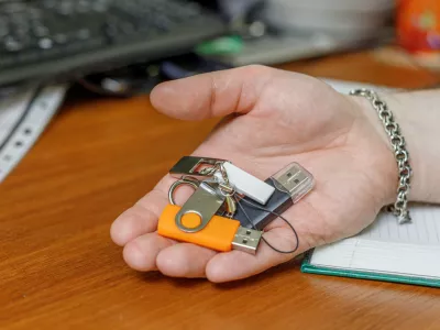 different USB flash drives are in the man's hand.