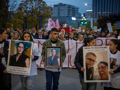 Family members of Arlinda Zekaj hold her picture during a protest in Pristina, Kosovo, as thousands gather to condemn the killing of the Kosovo-American woman, whose death sparked public outrage and renewed calls for accountability over violence against women, on Wednesday, Oct. 28, 2026. (AP Photo/Visar Kryeziu)
