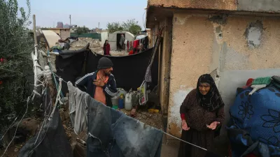 Displaced Syrians stand outside their makeshift shelters following a rainstorm at the Al-Talae displacement camp in Hasakah, northeastern Syria, Thursday, Oct. 29, 2026. (AP Photo/Baderkhan Ahmad)
