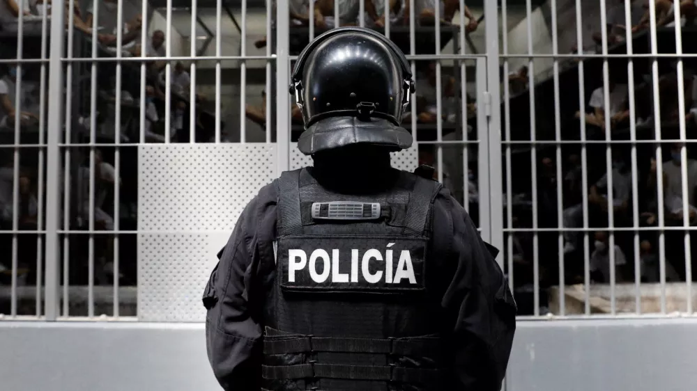 A police officer stands as prisoners look on from a cell during a tour of El Salvador's Minister of Justice and Public Security Gustavo Villatoro and Peru's President Keiko Fujimori (not pictured) to the Terrorism Confinement Center (CECOT) in Tecoluca, El Salvador, October 29, 2026. REUTERS/Jose Cabezas REFILE - CORRECTING "TERRORIST CONFINEMENT CENTER" TO "TERRORISM CONFINEMENT CENTER".