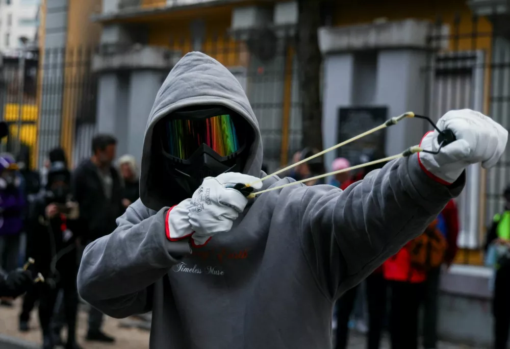 A protester uses a slingshot during an anti-government protest in Tirana, Albania, October 31, 2026. REUTERS/Florion Goga