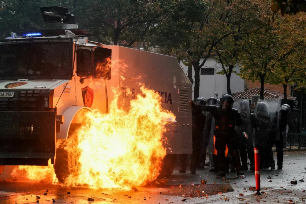 Flames rise after the impact of a petrol bomb next to police officers in riot gear during an anti-government protest in Tirana, Albania, October 31, 2026. REUTERS/Florion Goga   TPX IMAGES OF THE DAY