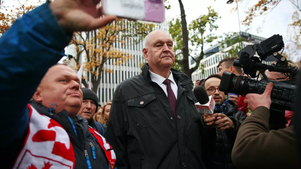 Suspended President of the Polish Constitutional Tribunal Bogdan Swieczkowski, center, attends a protest in front of the Constitutional Court in Warsaw, Poland, Saturday, Oct. 31, 2026. (AP Photo/Beata Zawrzel)